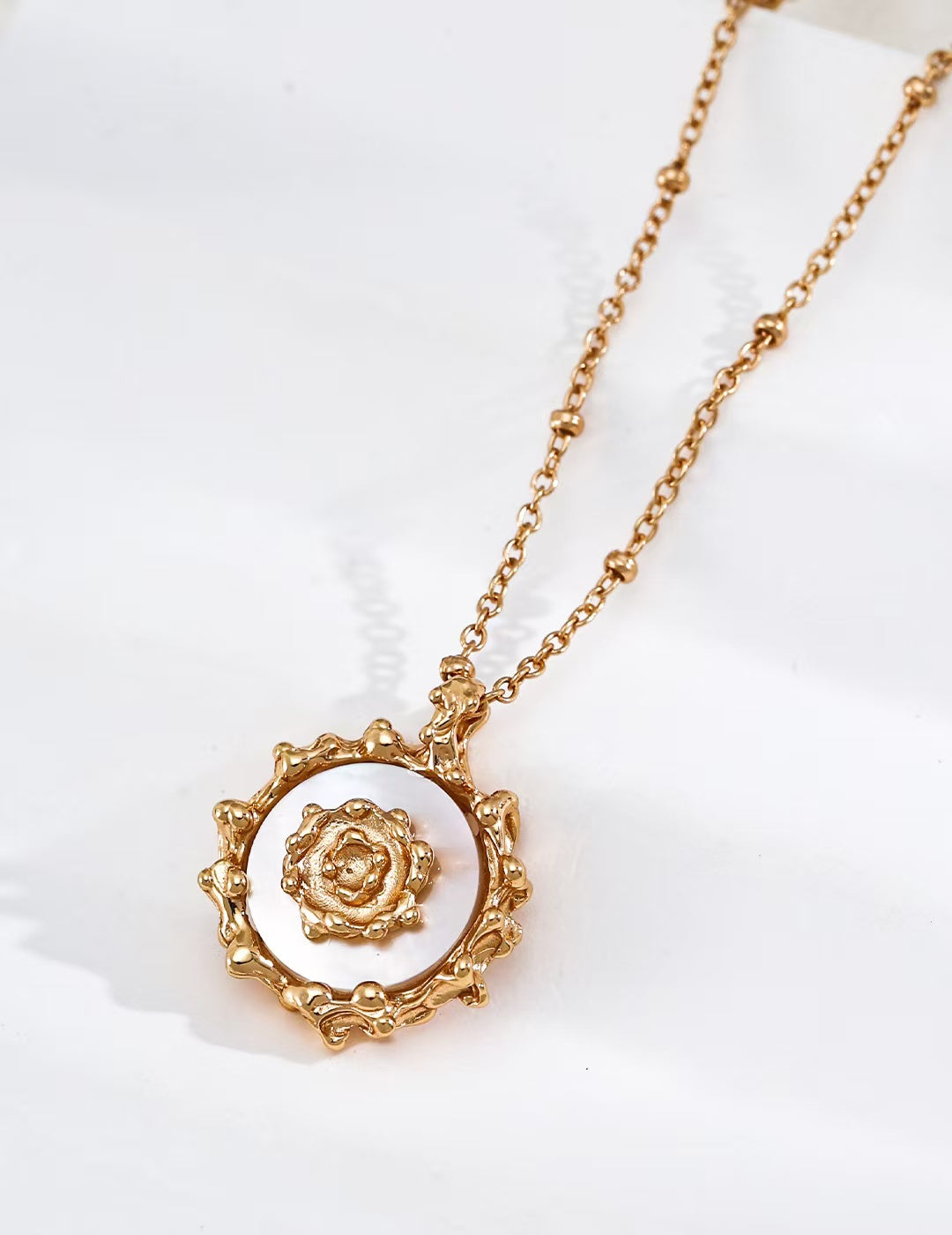 Mother-of-pearl necklace with sun-inspired design.
