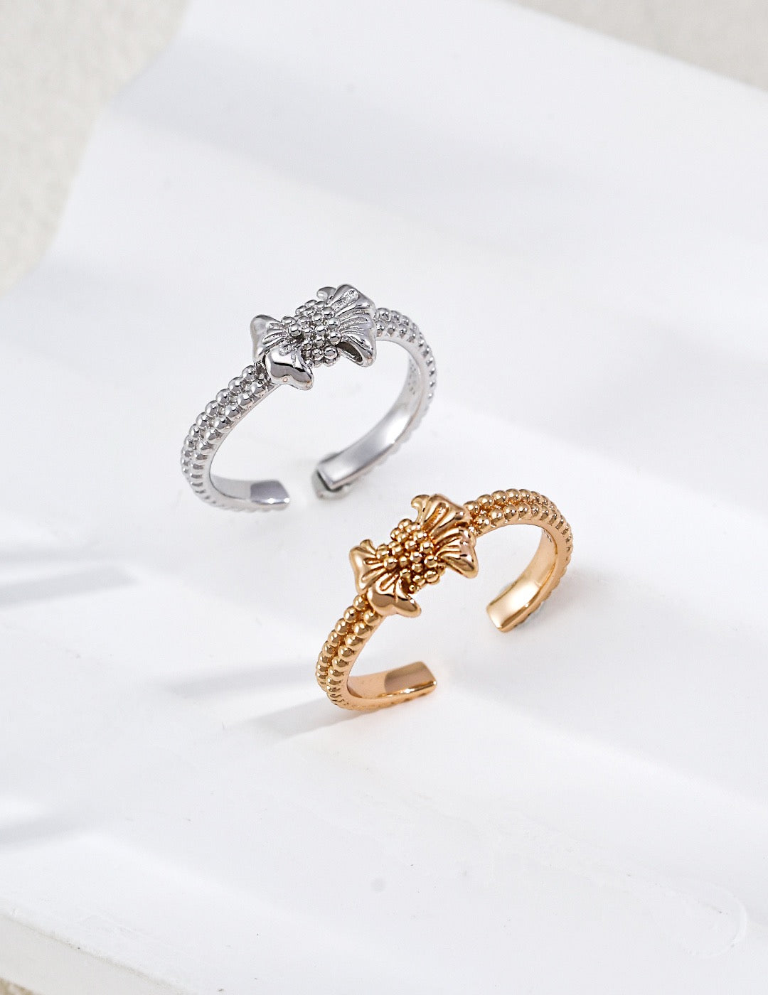 Gilded bow ring. Its crinkled texture brings an innate vintage charm, accented with dangling teardrop zircon stones that embody sophisticated grace.